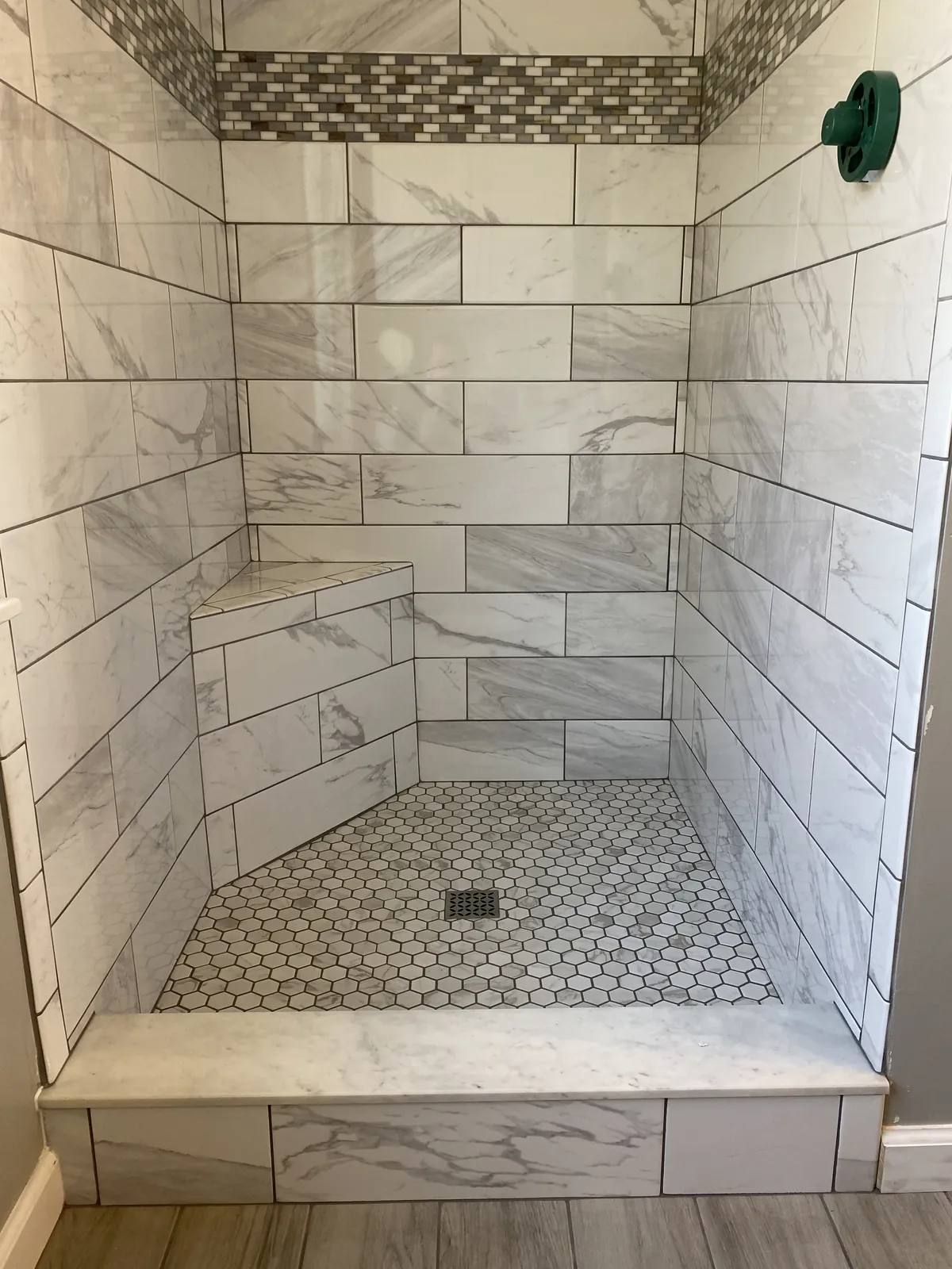 Marble subway tile shower with glass enclosure and brass fixtures.